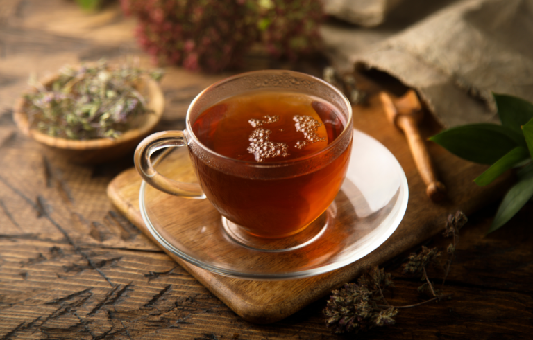 Une tasse de tisane Aloe Blossom sur une table en bois.