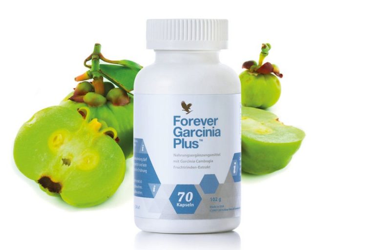Une bouteille de garcinia plus éternel à côté d’un bouquet de fruits.