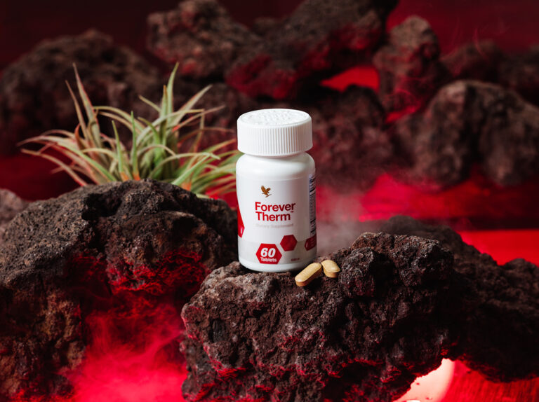 Une bouteille de Forever Therm posée au sommet d’un rocher.