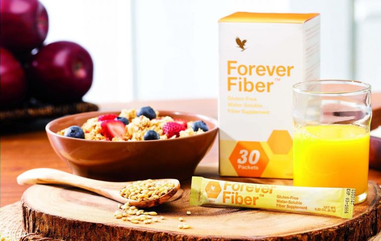 Une bouteille de Forever Fibre est à côté d'un jus d'orange et d'un bol de granola.
